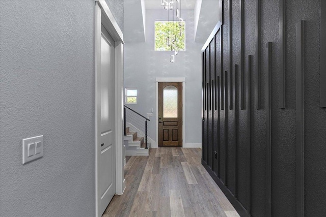 103 W Pauwela Ln, Bastrop, TX 78602 - foyer featuring stairs, wood finished floors, a chandelier, a textured wall, and a towering ceiling
