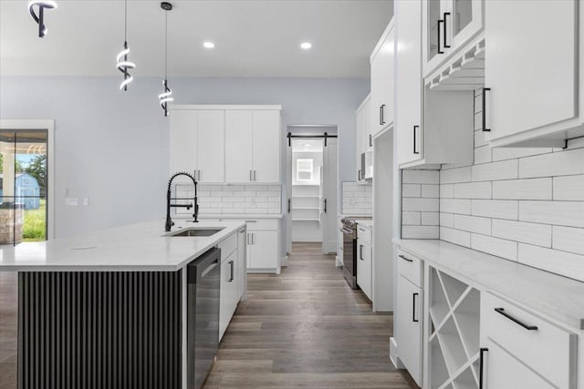 103 W Pauwela Ln, Bastrop, TX 78602 - kitchen with appliances with stainless steel finishes, a center island with sink, dark wood-style floors, white cabinetry, and recessed lighting