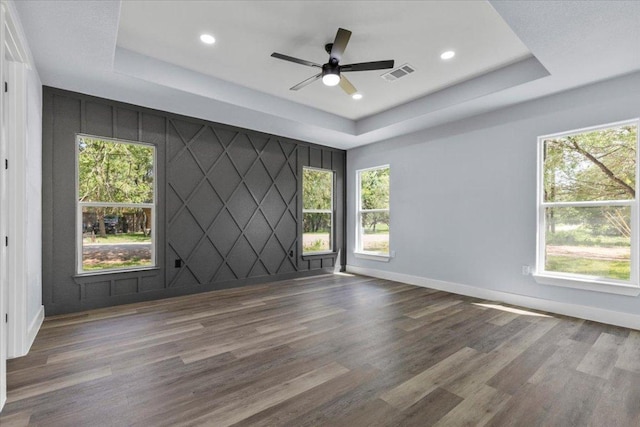 103 W Pauwela Ln, Bastrop, TX 78602 - spare room featuring a raised ceiling, wood finished floors, recessed lighting, a ceiling fan, and an accent wall