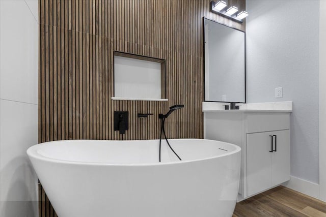 103 W Pauwela Ln, Bastrop, TX 78602 - full bathroom with vanity, a freestanding tub, and wood finished floors