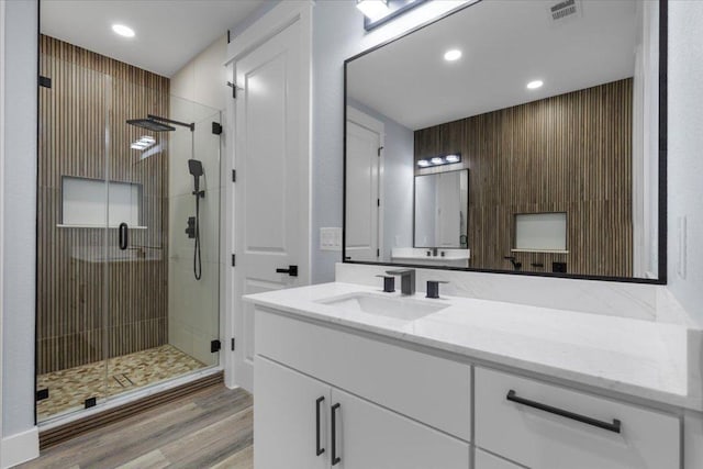 103 W Pauwela Ln, Bastrop, TX 78602 - full bathroom with vanity, a shower stall, wood finished floors, and recessed lighting