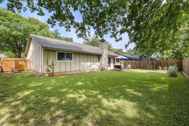 2508 Baxter Dr, Austin, TX 78745 - back of property featuring board and batten siding, a chimney, a fenced backyard, a patio, and a gate