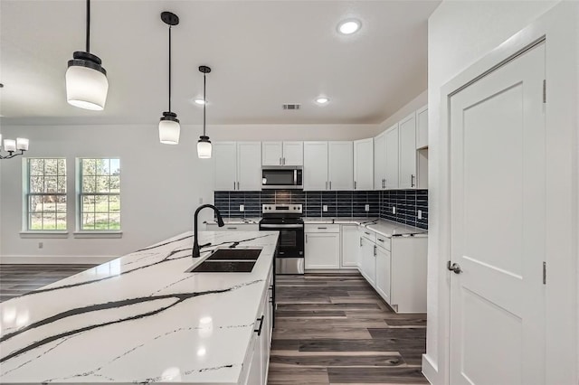 343 Nene Ln, Bastrop, TX 78602 - kitchen featuring stainless steel appliances, dark wood-style flooring, recessed lighting, tasteful backsplash, and white cabinets