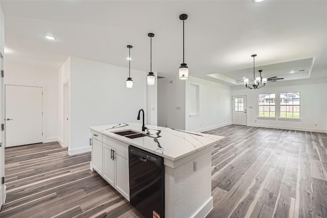 343 Nene Ln, Bastrop, TX 78602 - kitchen with black dishwasher, wood finished floors, a raised ceiling, a chandelier, and decorative light fixtures