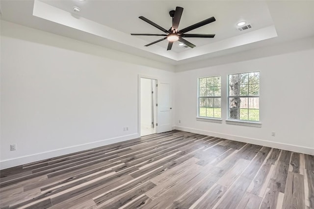 343 Nene Ln, Bastrop, TX 78602 - empty room with a tray ceiling, wood finished floors, ceiling fan, and recessed lighting