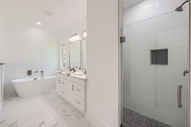 343 Nene Ln, Bastrop, TX 78602 - full bathroom featuring a shower stall, double vanity, a freestanding tub, marble look tile flooring, and wainscoting