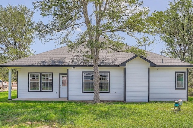 343 Nene Ln, Bastrop, TX 78602 - back of house featuring a shingled roof and a lawn