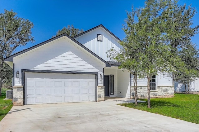 343 Nene Ln, Bastrop, TX 78602 - view of front of house with stone siding, concrete driveway, board and batten siding, and an attached garage