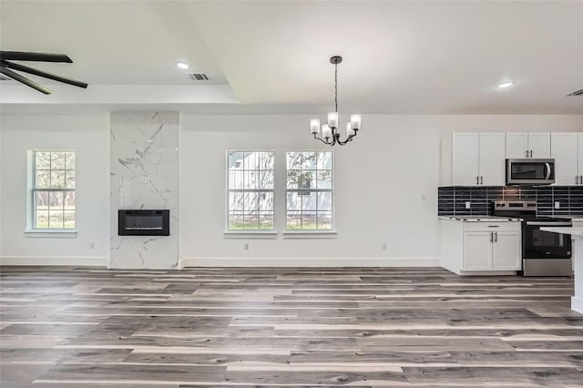343 Nene Ln, Bastrop, TX 78602 - kitchen featuring stainless steel appliances, open floor plan, heating unit, wood finished floors, and recessed lighting