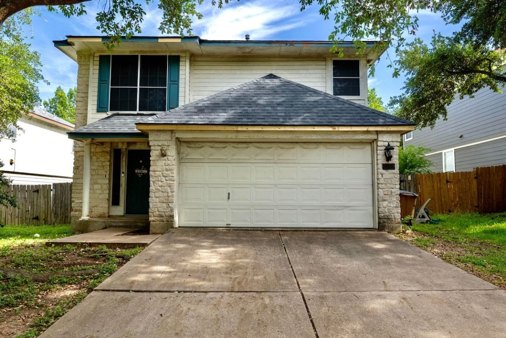 1311 Strickland Dr, Austin, TX 78748 - traditional-style home featuring stone siding, driveway, an attached garage, and roof with shingles