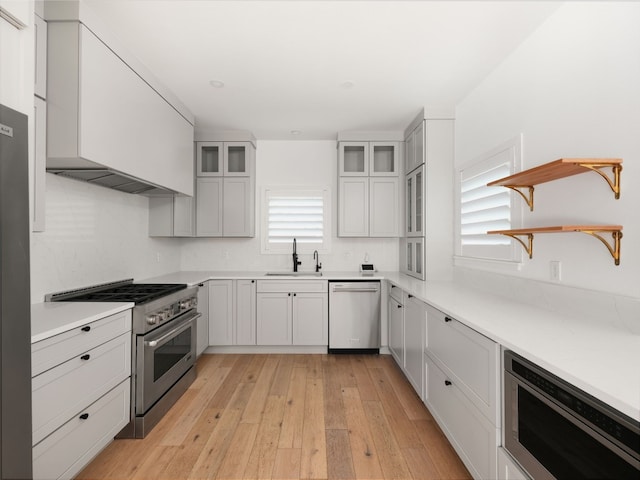 4105 Mcbrine Pl, Austin, TX 78746 - kitchen featuring stainless steel appliances, light wood-style floors, backsplash, open shelves, and light countertops