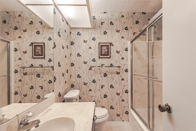 2008 Sandberg Dr, Austin, TX 78752 - bathroom featuring wallpapered walls, vanity, a textured ceiling, combined bath / shower with glass door, and tile patterned floors