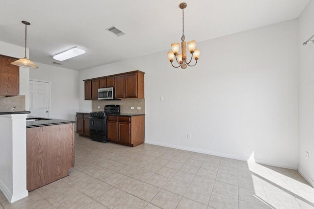 1900 Little Elm Trl Unit 98, Cedar Park, TX 78613 - kitchen with black gas stove, stainless steel microwave, backsplash, a chandelier, and dark countertops