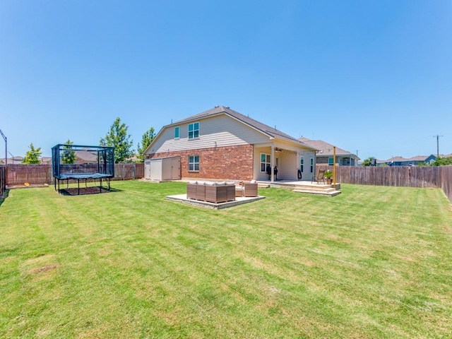 1329 Nokota Bnd, Georgetown, TX 78626 - back of property with a trampoline, brick siding, a fenced backyard, an outdoor hangout area, and a patio