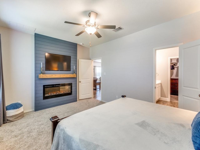 1329 Nokota Bnd, Georgetown, TX 78626 - carpeted bedroom with a large fireplace, ensuite bath, and ceiling fan