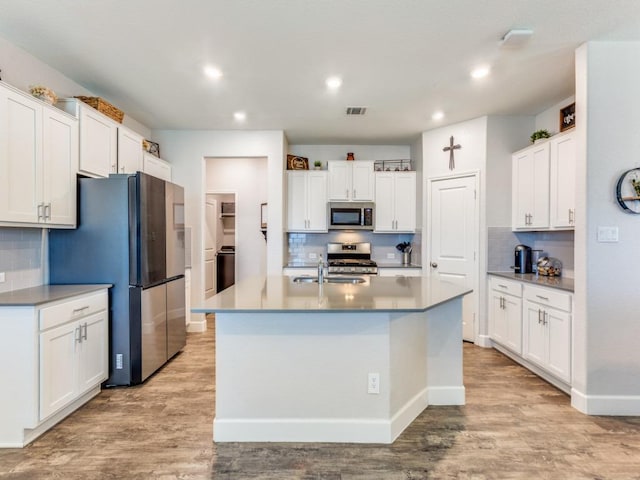 1329 Nokota Bnd, Georgetown, TX 78626 - kitchen featuring stainless steel appliances, backsplash, light wood-style flooring, white cabinets, and recessed lighting