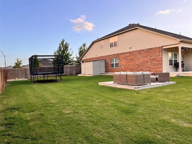 1329 Nokota Bnd, Georgetown, TX 78626 - rear view of property with a trampoline, a fenced backyard, brick siding, a patio, and an outdoor living space