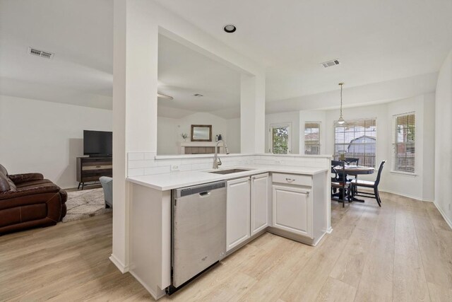 1643 Abbey Ln, Cedar Park, TX 78613 - kitchen featuring stainless steel dishwasher, light countertops, light wood finished floors, open floor plan, and hanging light fixtures