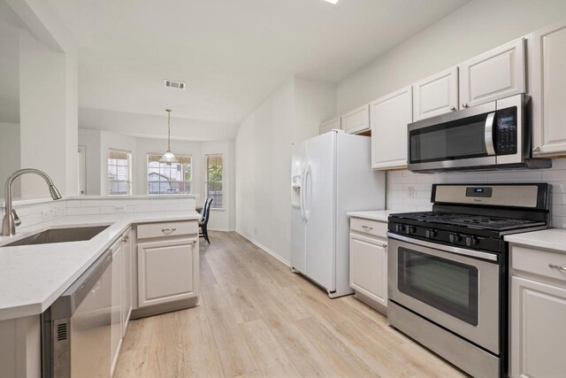 1643 Abbey Ln, Cedar Park, TX 78613 - kitchen featuring stainless steel appliances, light wood-style flooring, decorative backsplash, light countertops, and white cabinets