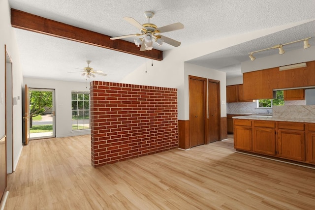 6804 Miranda Dr, Austin, TX 78752 - kitchen with brown cabinets, a ceiling fan, a textured ceiling, light countertops, and light wood-style flooring
