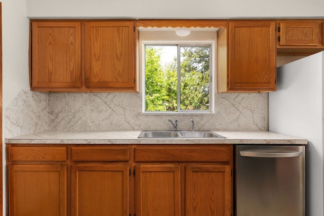 6804 Miranda Dr, Austin, TX 78752 - kitchen featuring appliances with stainless steel finishes, light countertops, tasteful backsplash, and brown cabinetry