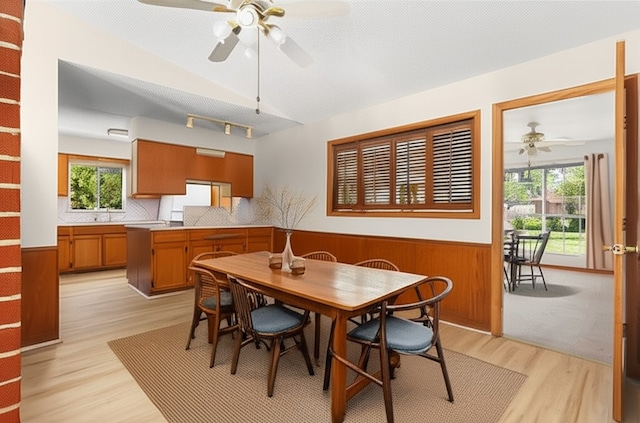 6804 Miranda Dr, Austin, TX 78752 - dining area featuring ceiling fan, a wainscoted wall, plenty of natural light, light wood-style flooring, and wood walls