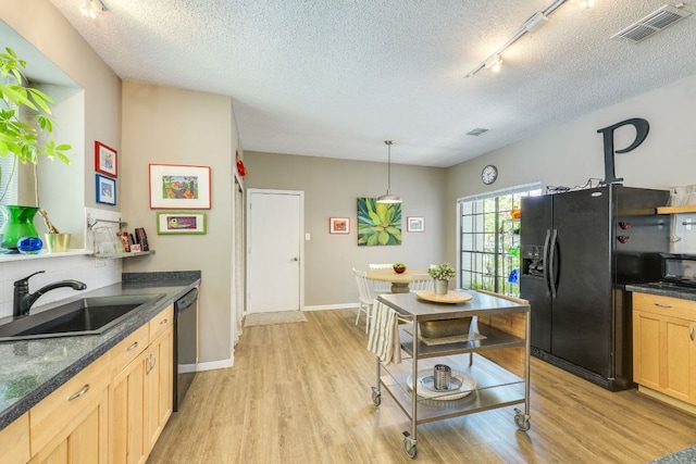 5808 Abilene Trl, Austin, TX 78749 - kitchen with black appliances, light wood-type flooring, dark countertops, a textured ceiling, and light brown cabinetry
