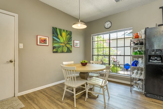 5808 Abilene Trl, Austin, TX 78749 - dining room featuring wood finished floors, a textured ceiling, and vaulted ceiling