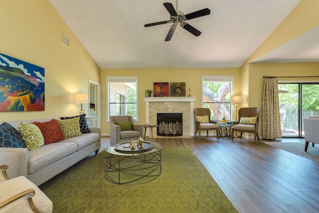 5808 Abilene Trl, Austin, TX 78749 - living room featuring wood finished floors, healthy amount of natural light, a tile fireplace, ceiling fan, and high vaulted ceiling