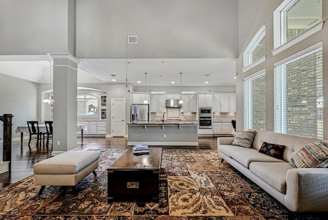 318 Gaspar Bnd, Cedar Park, TX 78613 - living area featuring a towering ceiling, dark wood-type flooring, plenty of natural light, ornate columns, and recessed lighting