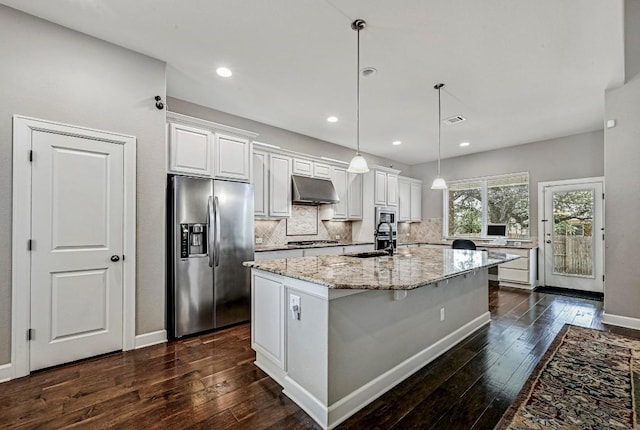 318 Gaspar Bnd, Cedar Park, TX 78613 - kitchen featuring appliances with stainless steel finishes, under cabinet range hood, decorative backsplash, dark wood finished floors, and recessed lighting