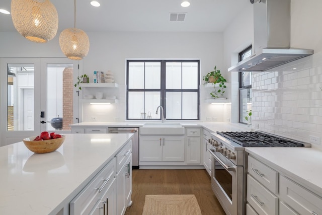 3108 Chennault St, Austin, TX 78723 - kitchen featuring open shelves, stainless steel appliances, range hood, dark wood-type flooring, and white cabinets