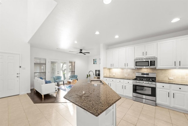 11400 W Parmer Ln Unit 44, Cedar Park, TX 78613 - kitchen with stainless steel appliances, open floor plan, tasteful backsplash, light tile patterned floors, and white cabinetry