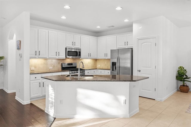 11400 W Parmer Ln Unit 44, Cedar Park, TX 78613 - kitchen with appliances with stainless steel finishes, arched walkways, a center island with sink, white cabinets, and tasteful backsplash
