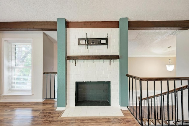 2505 Linwood Rd, Temple, TX 76502 - detailed view of a textured ceiling, wood finished floors, beam ceiling, and a brick fireplace