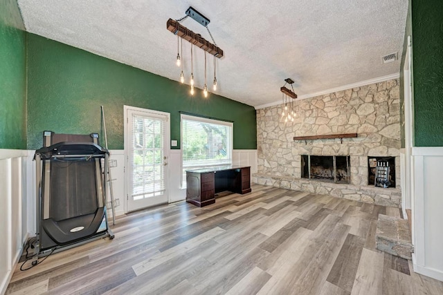 2505 Linwood Rd, Temple, TX 76502 - living area featuring a textured ceiling, a textured wall, wood finished floors, a fireplace, and a wainscoted wall