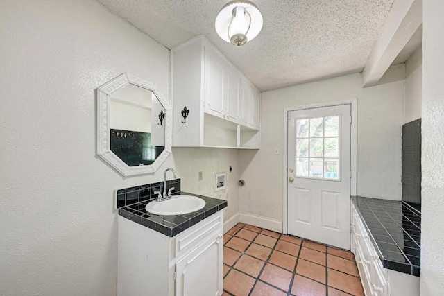 2505 Linwood Rd, Temple, TX 76502 - washroom with cabinet space, a textured ceiling, washer hookup, electric dryer hookup, and light tile patterned flooring