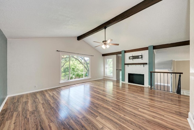 2505 Linwood Rd, Temple, TX 76502 - unfurnished living room with wood finished floors, a ceiling fan, a brick fireplace, and a textured ceiling