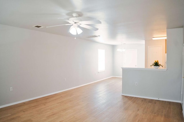 12805 Briarcreek Loop, Manor, TX 78653 - unfurnished room featuring ceiling fan, light wood finished floors, and a chandelier