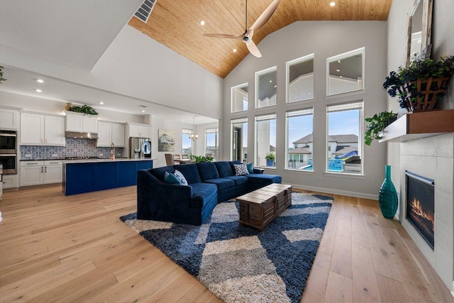 4509 Port Bari Dr, Leander, TX 78641 - living area with wooden ceiling, a glass covered fireplace, recessed lighting, high vaulted ceiling, and light wood-style flooring