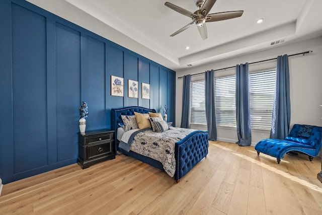 4509 Port Bari Dr, Leander, TX 78641 - bedroom with light wood-style flooring, recessed lighting, ceiling fan, and a raised ceiling
