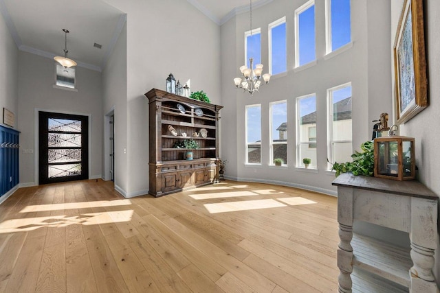 4509 Port Bari Dr, Leander, TX 78641 - foyer with a high ceiling, light wood-style flooring, ornamental molding, and a chandelier