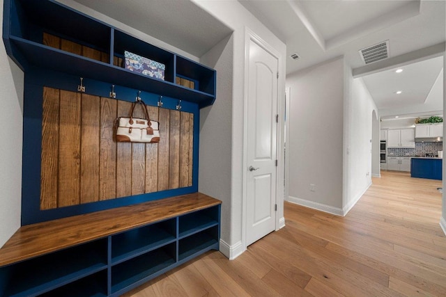 4509 Port Bari Dr, Leander, TX 78641 - mudroom with light wood-style flooring, a tray ceiling, recessed lighting, and arched walkways