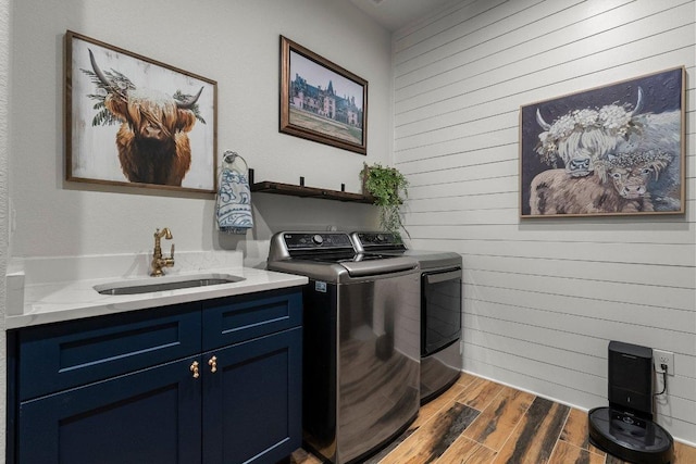 4509 Port Bari Dr, Leander, TX 78641 - washroom with separate washer and dryer, wooden walls, wood finished floors, and cabinet space