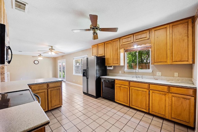 206 Woodland Trl, Belton, TX 76513 - kitchen featuring black dishwasher, light countertops, stainless steel fridge, and healthy amount of natural light