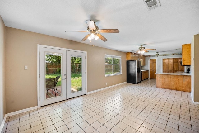 206 Woodland Trl, Belton, TX 76513 - kitchen with black fridge with ice dispenser, brown cabinets, french doors, and ceiling fan