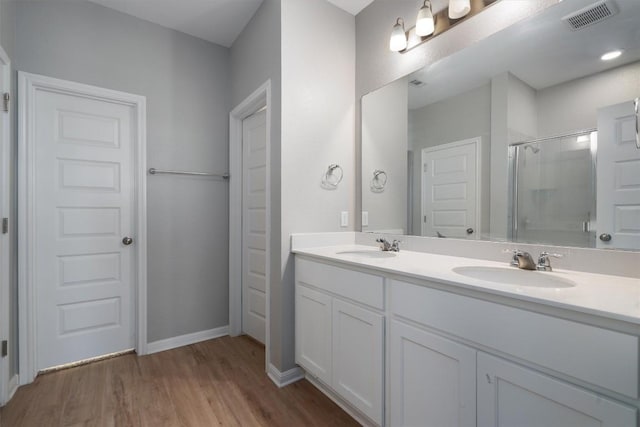 12003 Curlin Cv, Buda, TX 78610 - full bath with an enclosed shower, double vanity, and wood finished floors