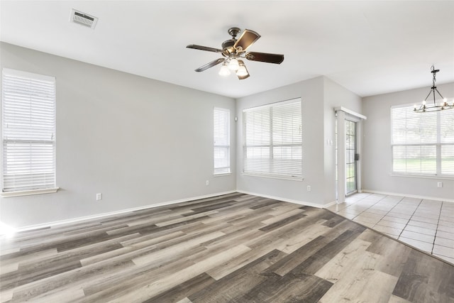 9405 Billingham Trl, Austin, TX 78717 - empty room with wood finished floors, a ceiling fan, and a chandelier