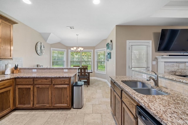 198 Sheridan Loop, Belton, TX 76513 - kitchen with decorative backsplash, light stone counters, a peninsula, a fireplace, and hanging light fixtures