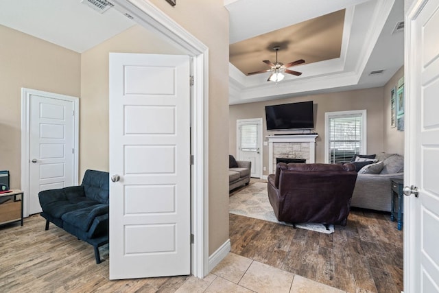 198 Sheridan Loop, Belton, TX 76513 - living room with ceiling fan, a raised ceiling, a fireplace, and wood finished floors